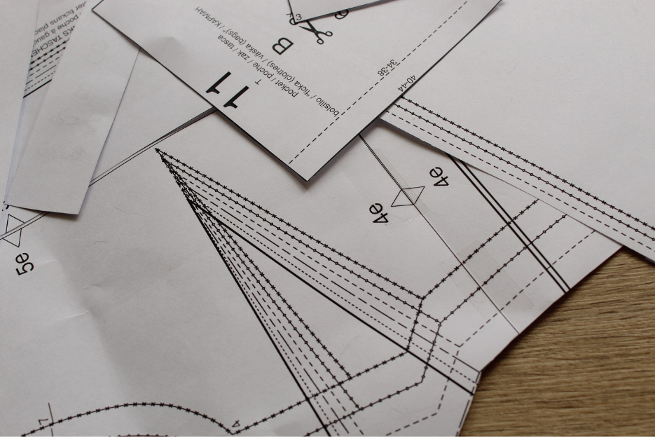 Flat lay of sewing patterns and fabric showing plus-size garment fit adjustments.