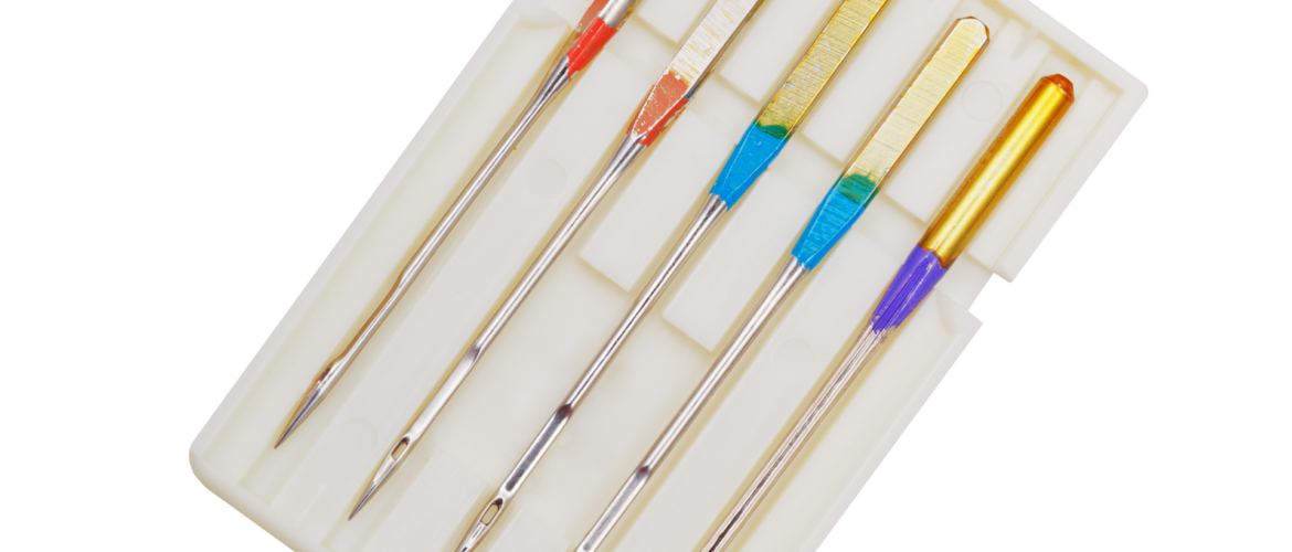 A collection of specialized sewing machine needles, illustrating essential supplies for professional garment fitting.
