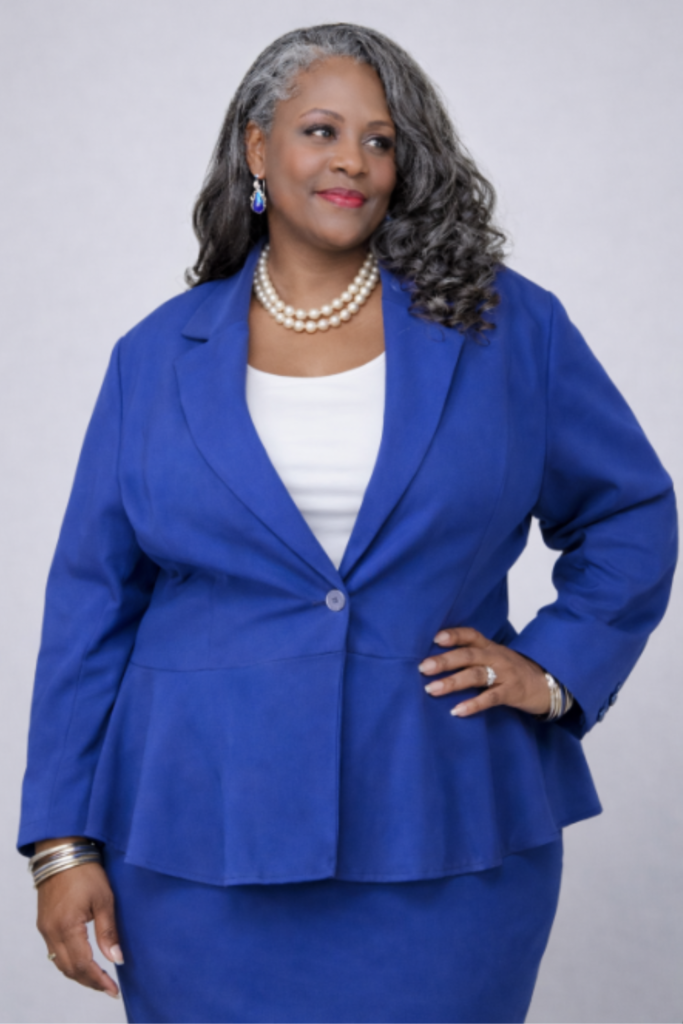 A model in a cobalt blue blazer illustrating common mass-produced fit issues for plus-size bodies, used as a teaching example at The Academy of Sewing.