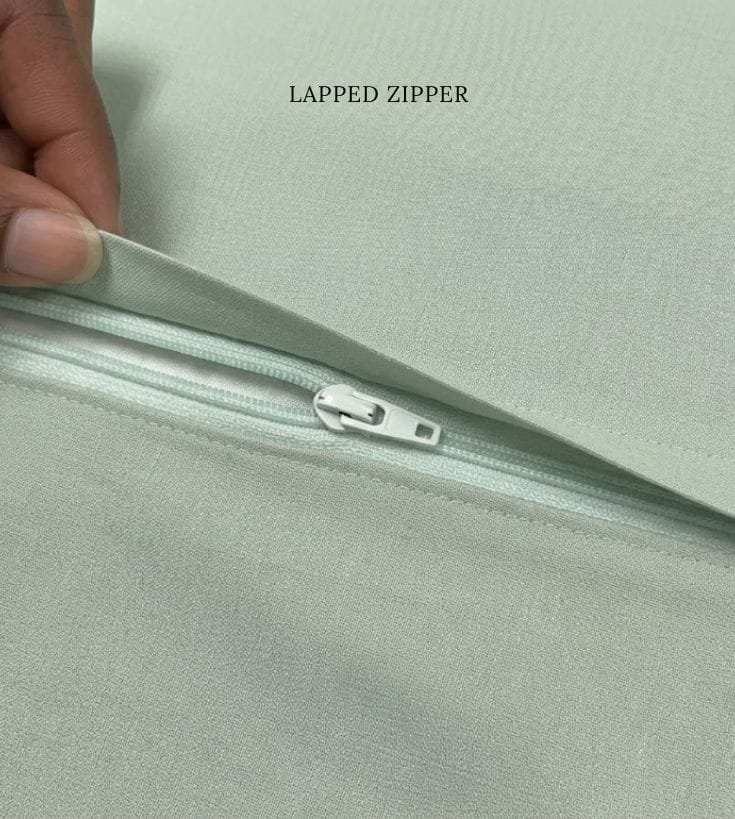 Close-up of a lapped zipper sewn into a garment seam, showing the folded overlap